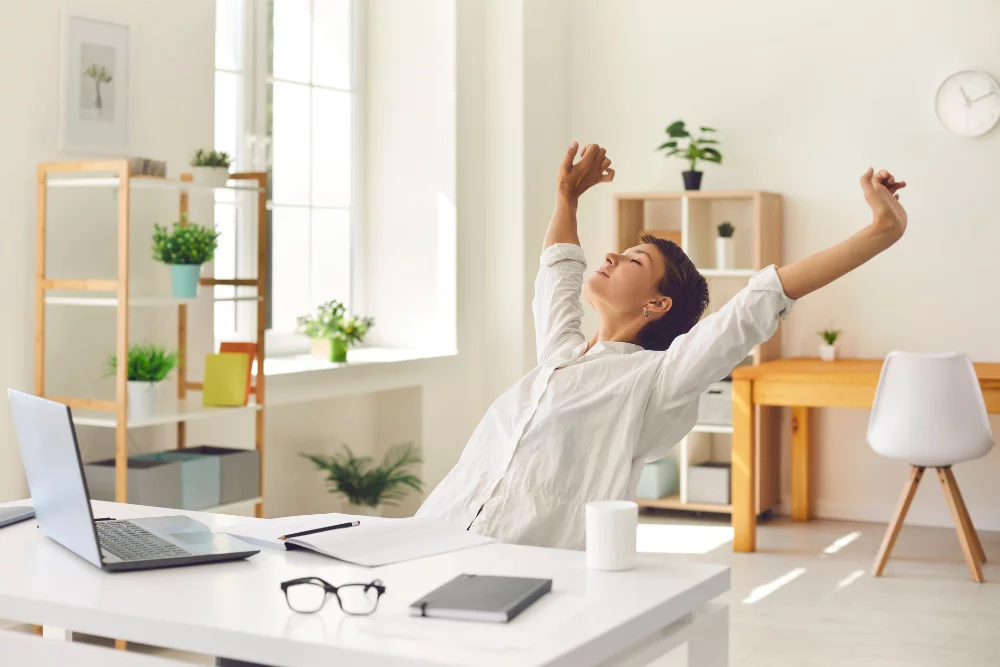 Person stretching beside a home office desk